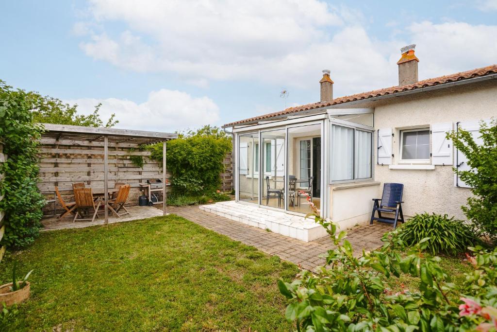 a garden with a patio and a house at Cottage Chaleureux Proche Ocean in Salles-sur-Mer