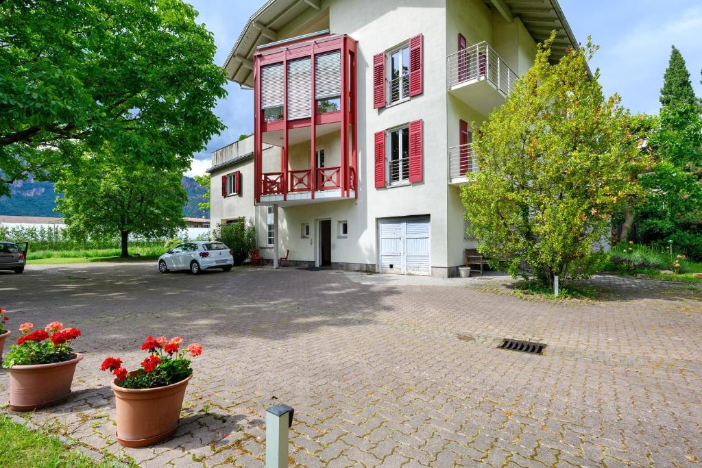 a building with red shutters and a parking lot at Apartment Gerwies in Bronzolo