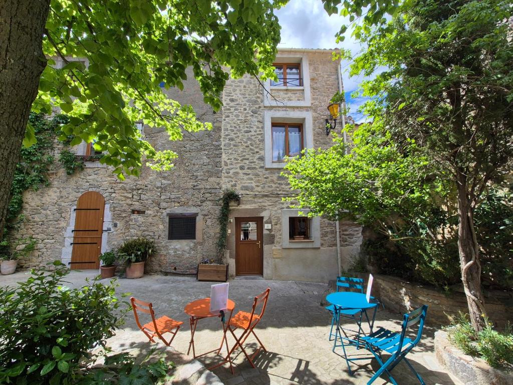 a group of chairs and tables in front of a house at Maison - Le Petit Bussac in Aigne