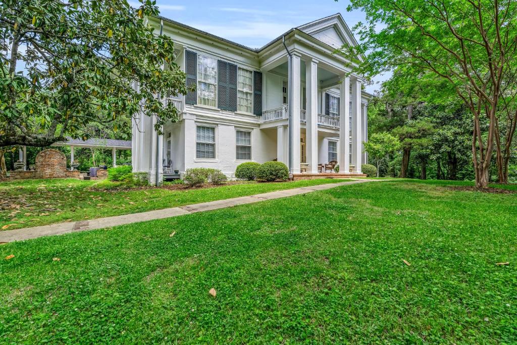 a large white house with a grass yard at The Montgomery B&B in Starkville