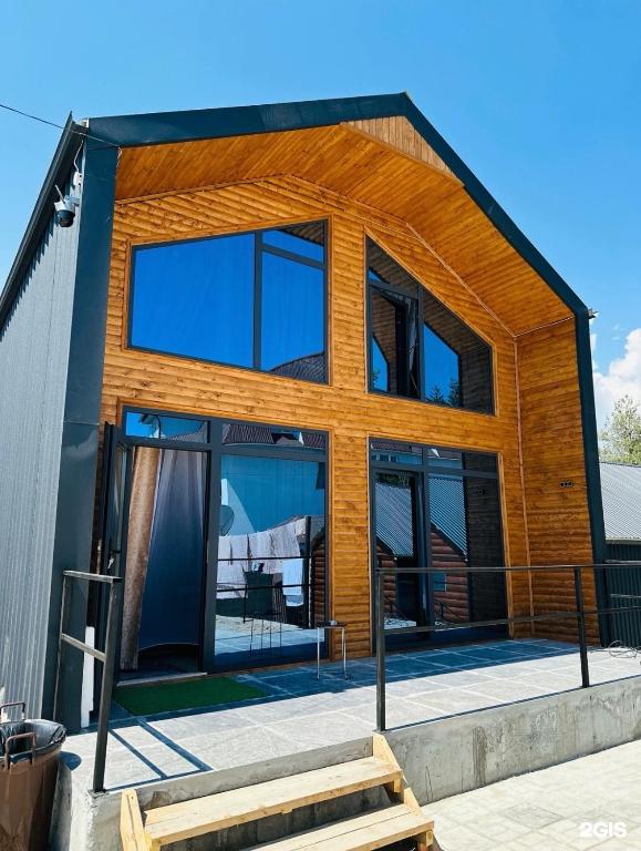 a modern house with glass doors and windows at Малинка in Cholpon-Ata