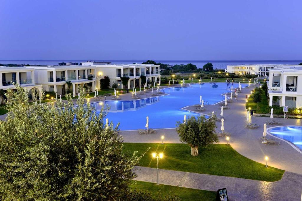 a large swimming pool in a resort at night at Levante Athletic Resort in Afantou