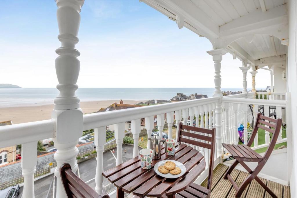 a table on a balcony with a view of the beach at 2 Bed in Woolacombe oc-shore1 in Woolacombe