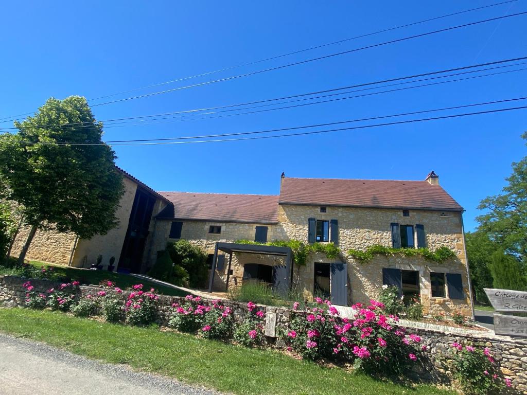 a stone house with flowers in front of it at Cottage de La Mothe in Marnac