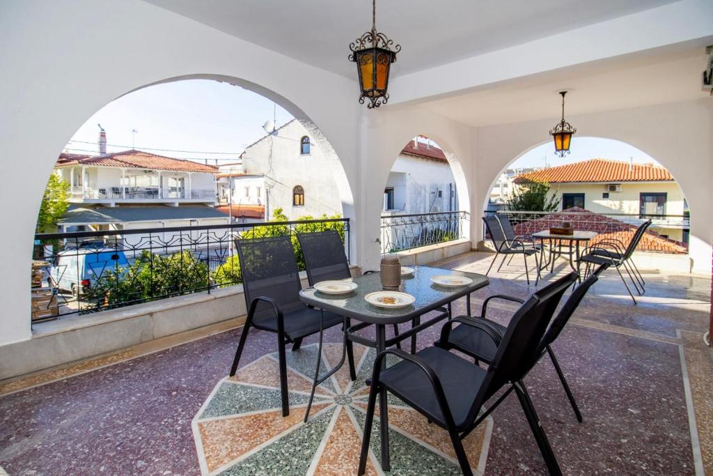 a patio with a table and chairs on a balcony at Jonathan Central Apartment in Pefkochori