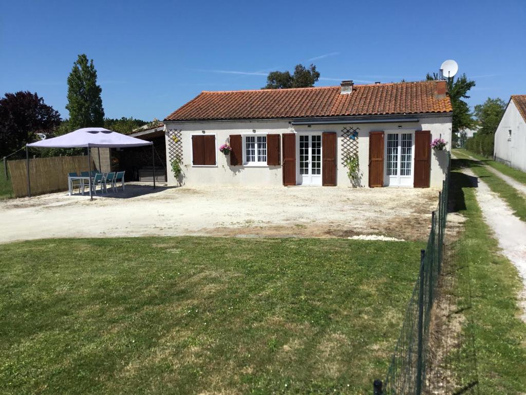 a small house with a fence and a yard at Bienvenue dans notre maison in Saint-Georges-dʼOléron