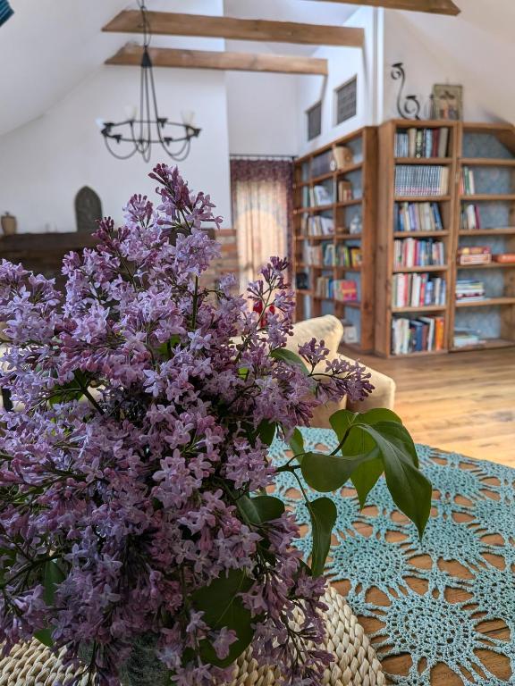 a vase of purple flowers sitting on a table at Forreset esencja natury - apartament z opcją sauny i balii in Gietrzwałd