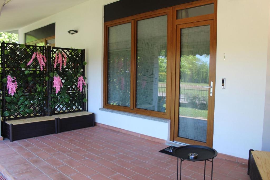 a room with a door and a window with pink flowers at I Tre Ulivi 1 in Mozzate