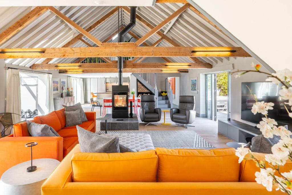 an open living room with orange couches and a tv at La Retraite in Wolferton