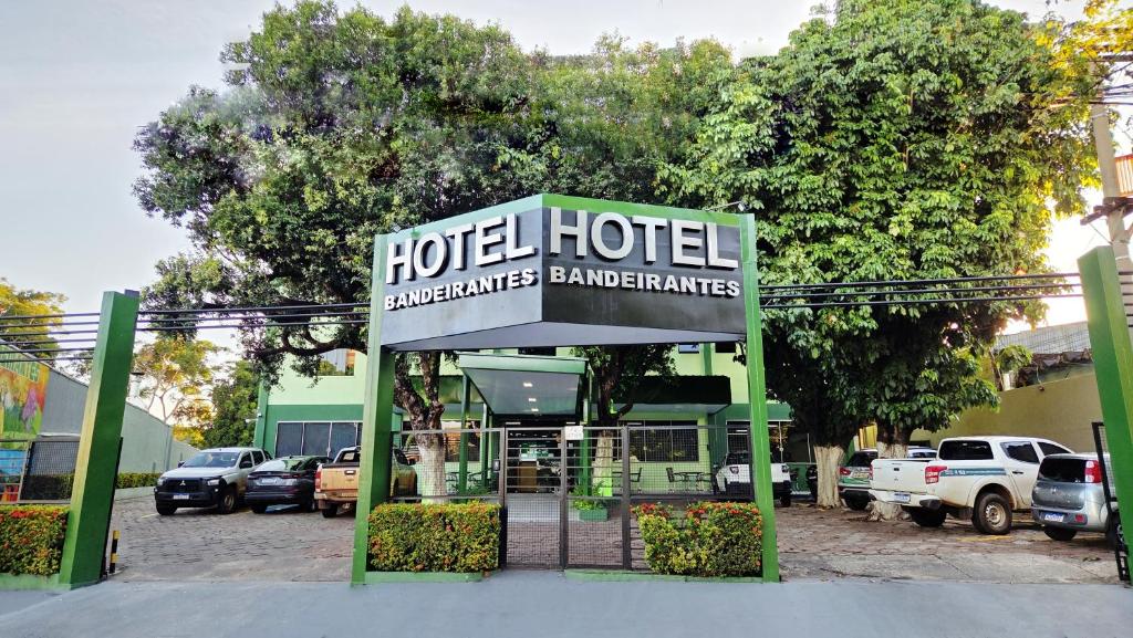 a hotel sign in front of a parking lot at Bandeirantes Hotel in Cuiabá
