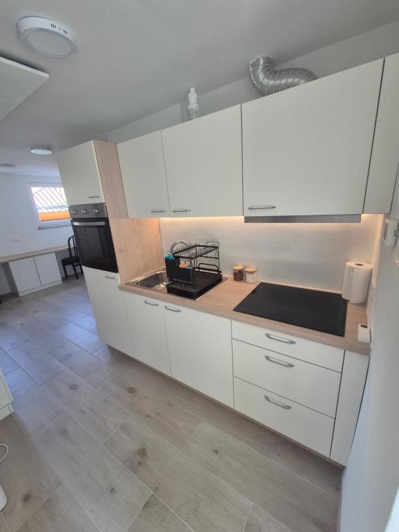 a kitchen with white cabinets and a counter top at Garsonjera Alina in Zgornje Gameljne