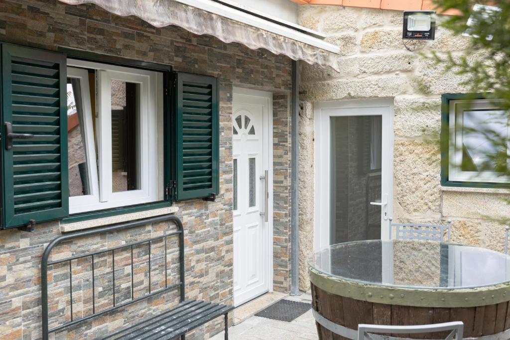 a house with a glass table in front of a door at Casa Fontenario in Vila Real