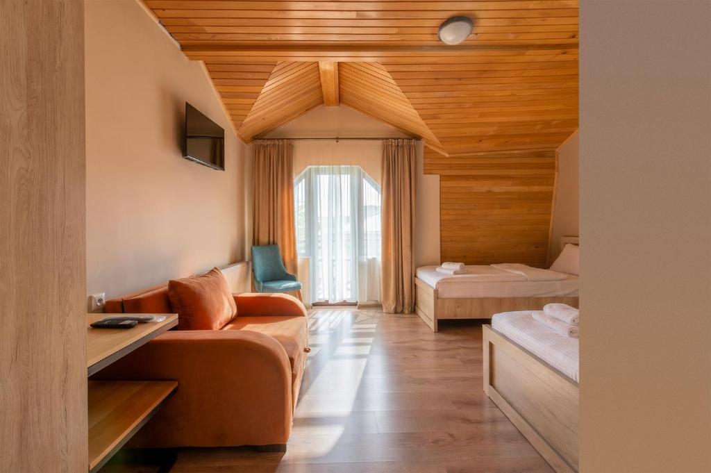 a living room with a couch and a bed at Hotel Babuda in Mestia in Mestia