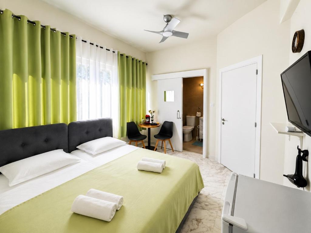 a bedroom with a large bed with green curtains at Smart Comfort RoomN3 with Private Bathroom in best Location Beach 250m in Limassol