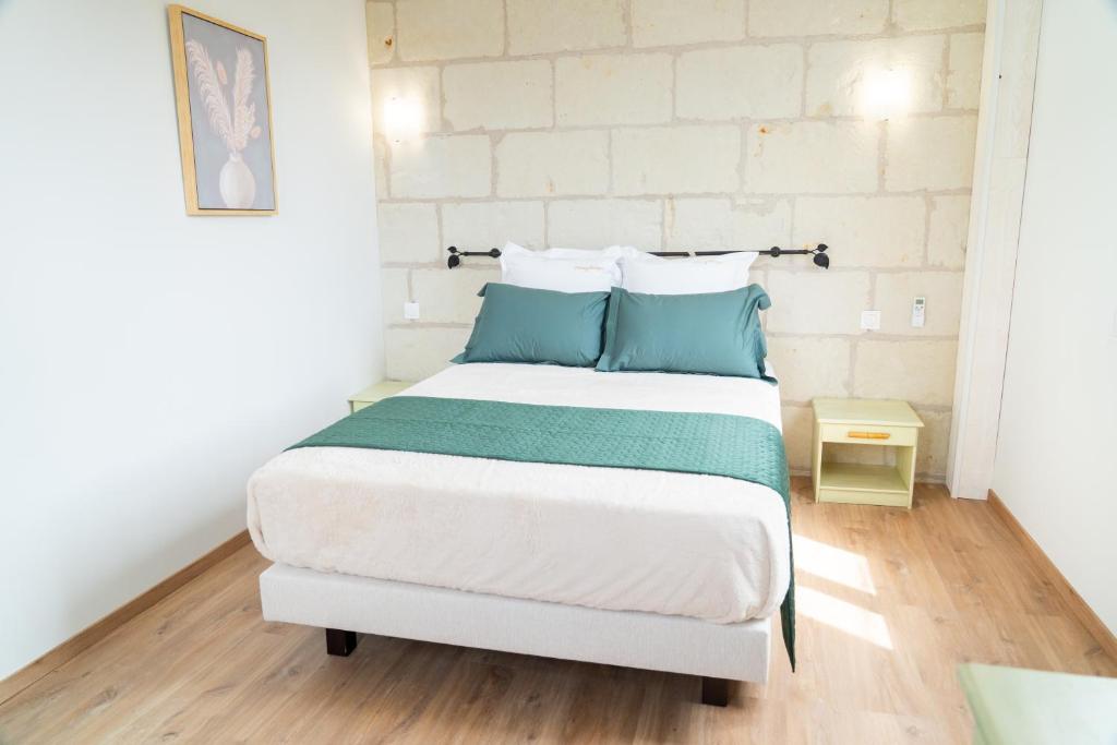 a bedroom with a large bed with blue pillows at Parnaydisiaque in Parnay