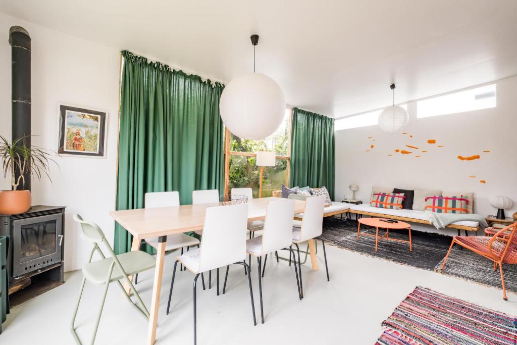 a dining room with green curtains and a table and chairs at 4BR, Garden & BBQ, 5min to Milícias Beach, Easy Park, Casa Yucca in São Roque