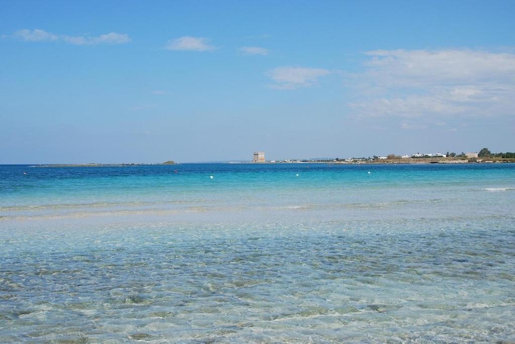a view of the ocean with the sand and water at Hotiday Porto Cesareo Spiaggia in Porto Cesareo