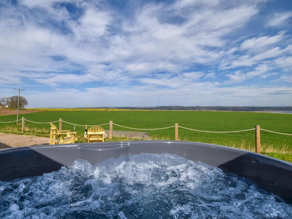 a bath tub filled with water in front of a field at 2 Bed in Arbroath oc-90316 in Inverkeilor