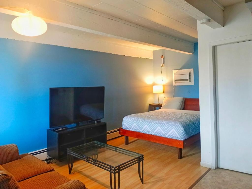 a room with a bed and a tv and a couch at Caravan Motel in Fort Saint John