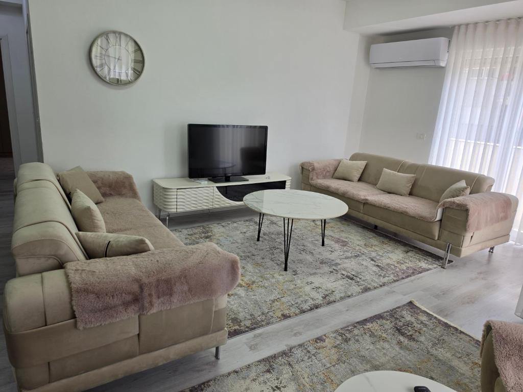 a living room with two couches and a tv at Lux Apartman Gostivar in Gostivar