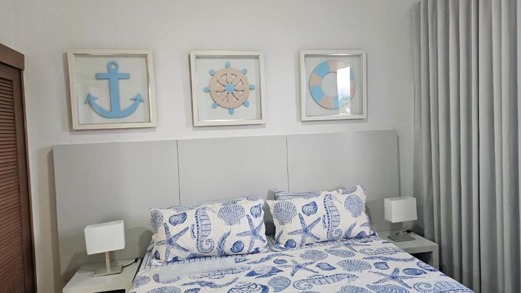 a bedroom with a bed and three pictures on the wall at Xonadu con dominio in Puerto Plata