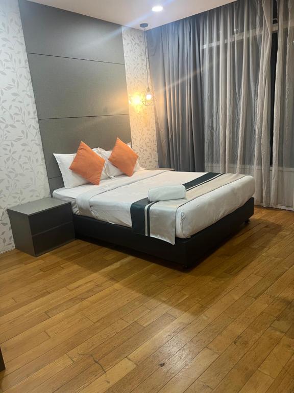 a bedroom with a bed with orange pillows on it at VORTEX Suites KLCC Premium BY RRP in Kuala Lumpur