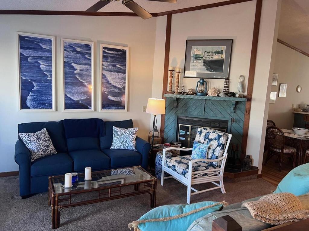 a living room with a blue couch and a fireplace at The Gallery in Kitty Hawk