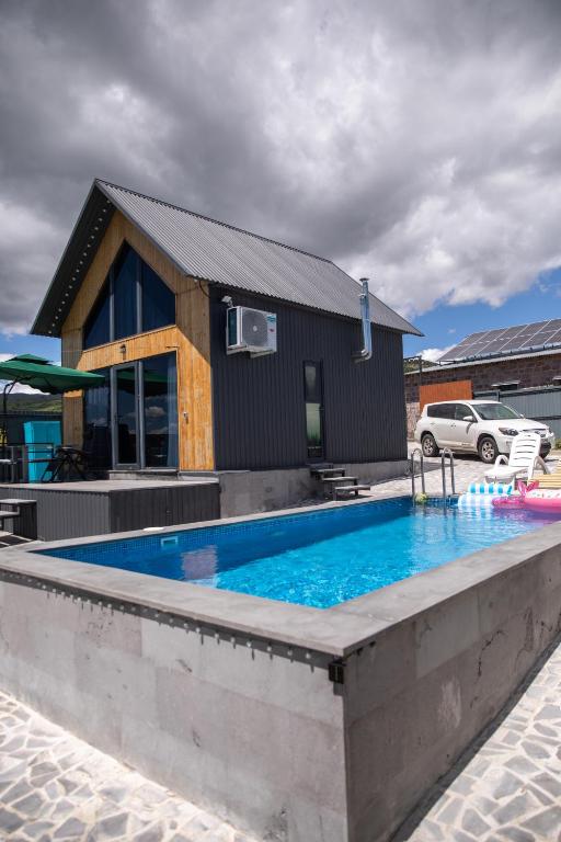 a swimming pool in front of a house at AAA Byurakan Rest House in Ashtarak