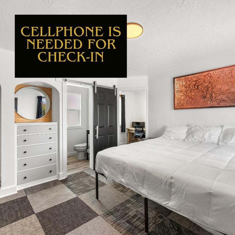 a bedroom with a white bed and a dresser at Copper Hill Suites in Butte