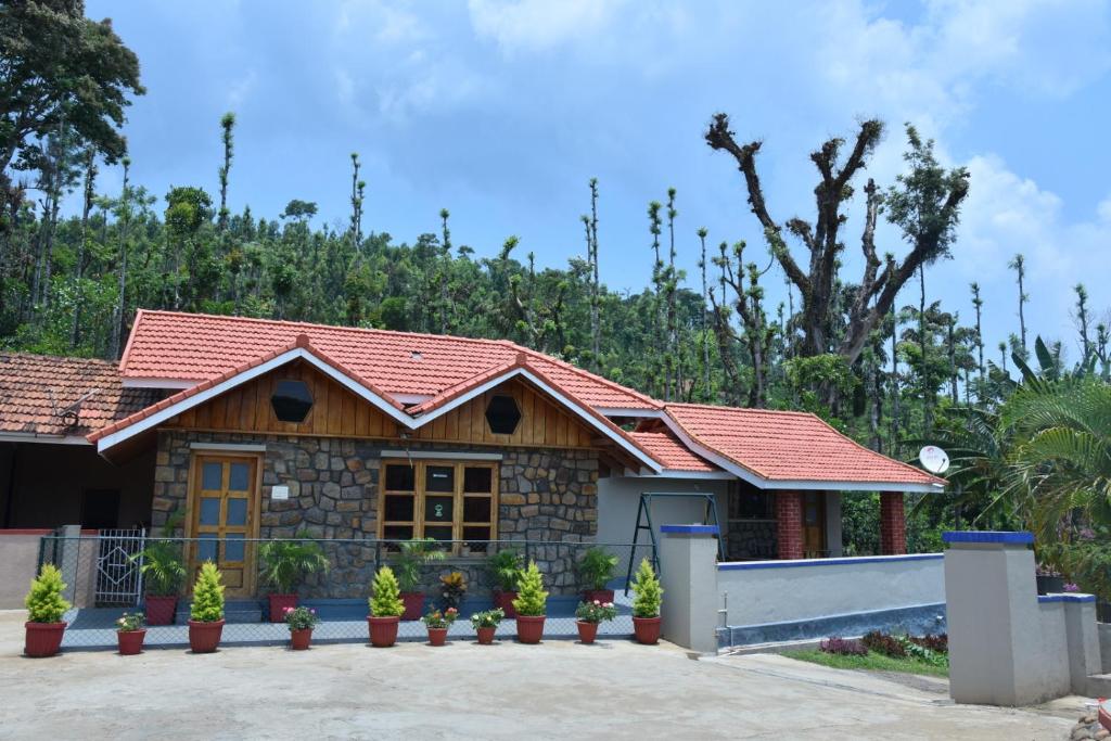 a house with a red roof at Hillwoods homestay in Somvārpet