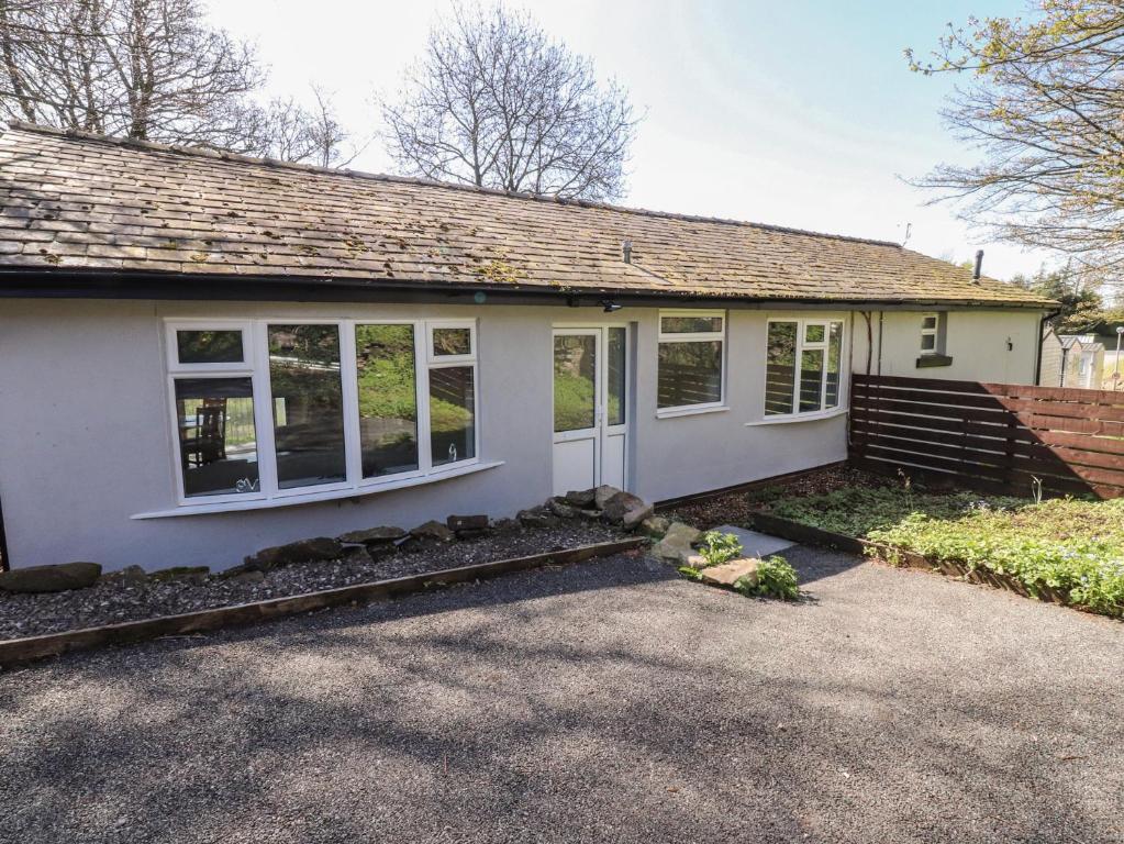 a small white house with windows and a driveway at Beacon Fell Cottage 1 in Preston