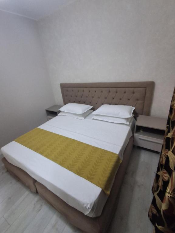 a bedroom with a large bed with a yellow blanket at holiday house in Durrës