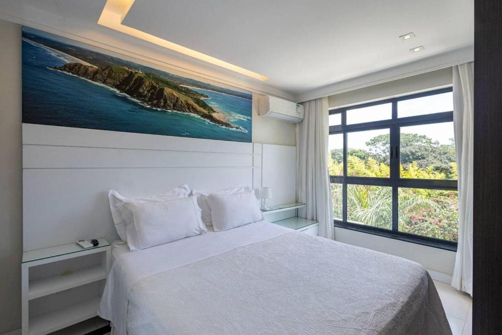 a bedroom with a white bed and a large window at Estudio232 - Asa Sul in Brasília