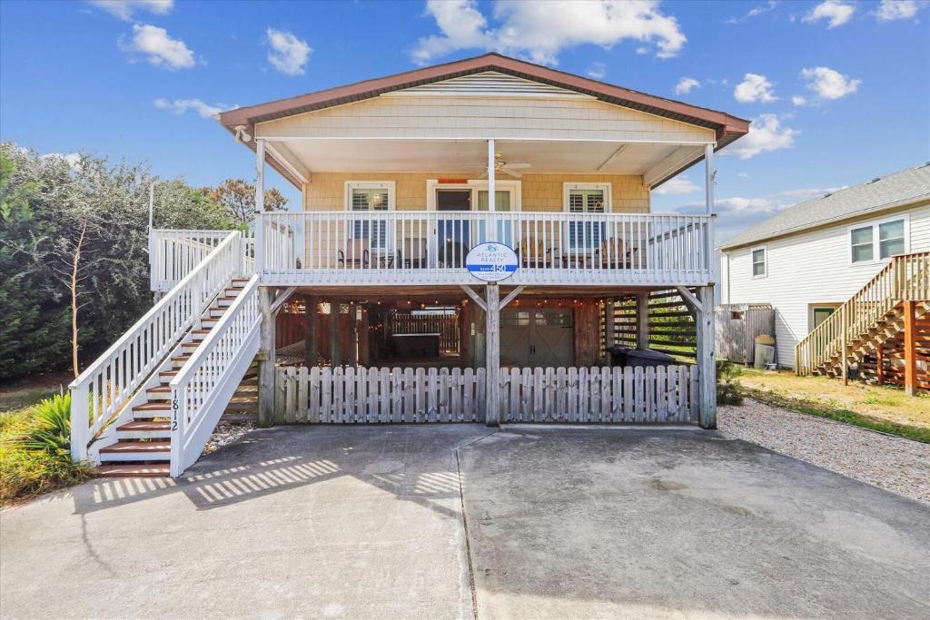 a house with a balcony and a basketball hoop at Sea Glass Shack in Kill Devil Hills
