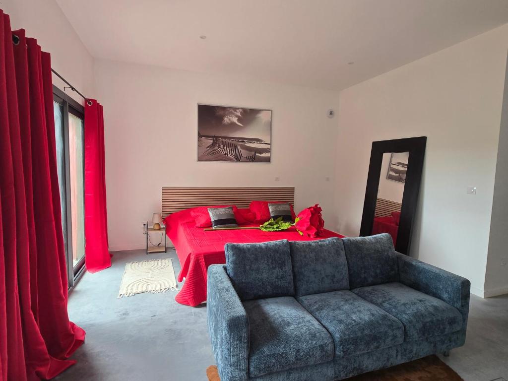 ein Schlafzimmer mit einem Bett, einer Couch und einer roten Decke in der Unterkunft L' Ecrin in Auch