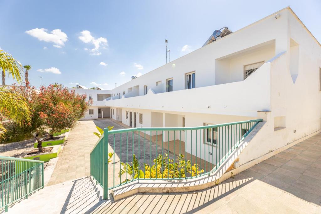 an exterior view of a white building with stairs at Appartamenti Mancaversa in Marina di Mancaversa