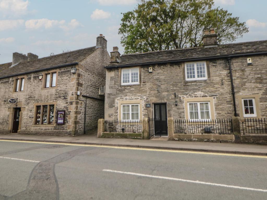 an old stone building on the side of a street at The Toll Bar in Castleton