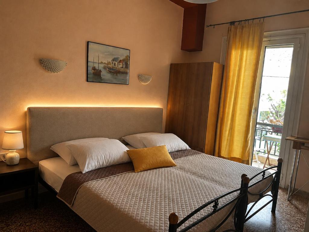 a bedroom with a bed with two pillows and a window at Retro Rooms in Loutra Edipsou