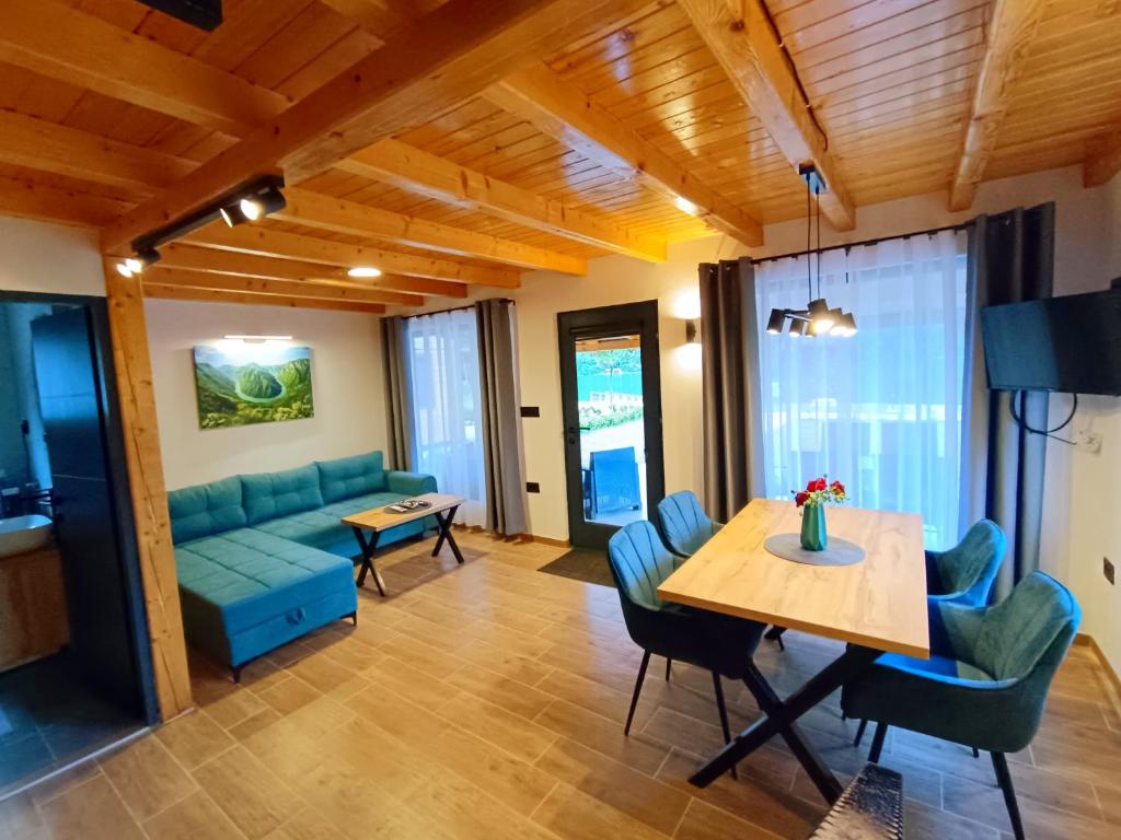 a living room with a blue couch and a table at Drina Escape - Lake View in Višegrad