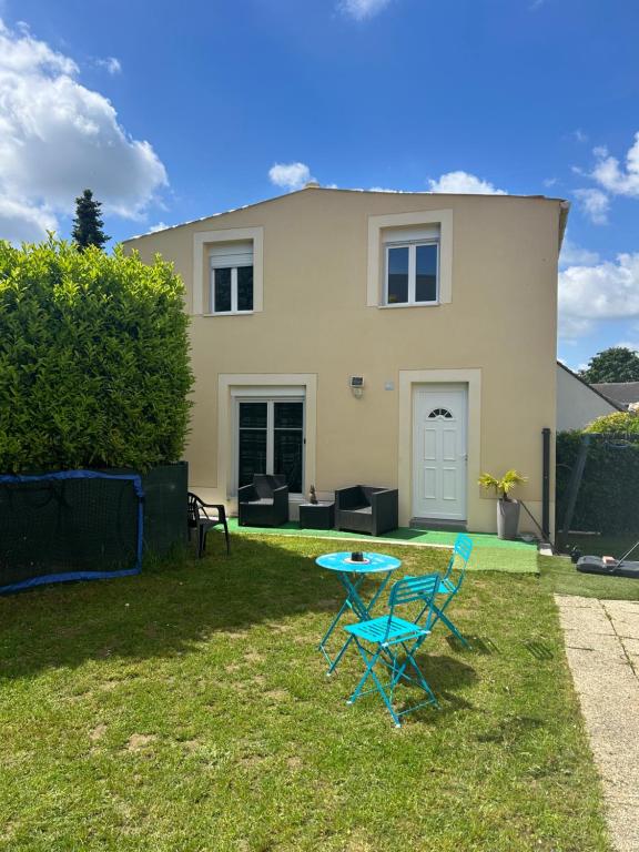 a table and chairs in front of a house at Family House in Beauvais