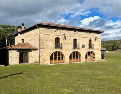 a large brick building in a field of grass at Nuestra Señora de Revenga in Regumiel de la Sierra