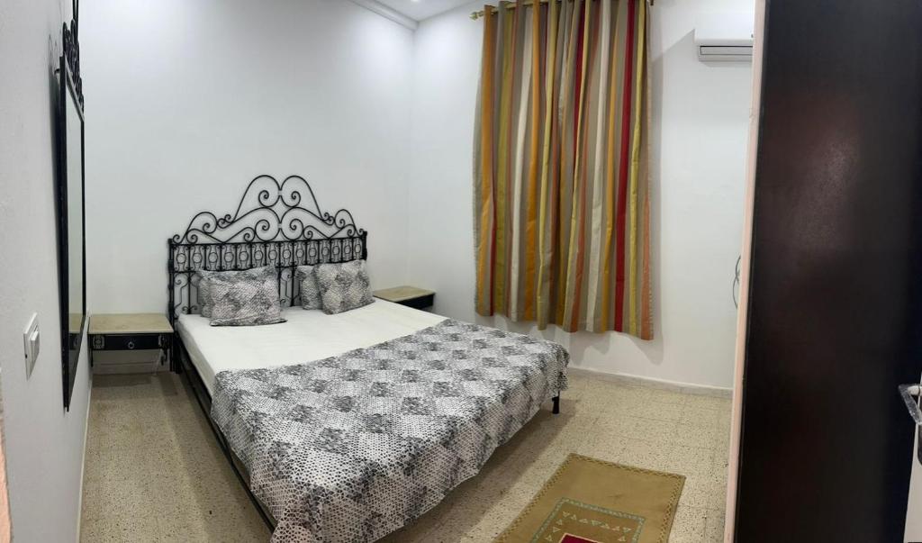 a bedroom with a bed in a room with a window at Dar Samir in Awlād ‘Umar