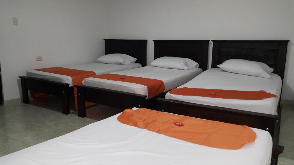 Postel nebo postele na pokoji v ubytování Aparta Hotel El Cacique Upar