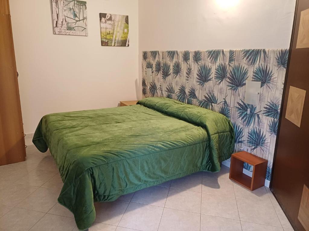 a bedroom with a bed with a green comforter at Confort home L da Vinci in Quattromiglio