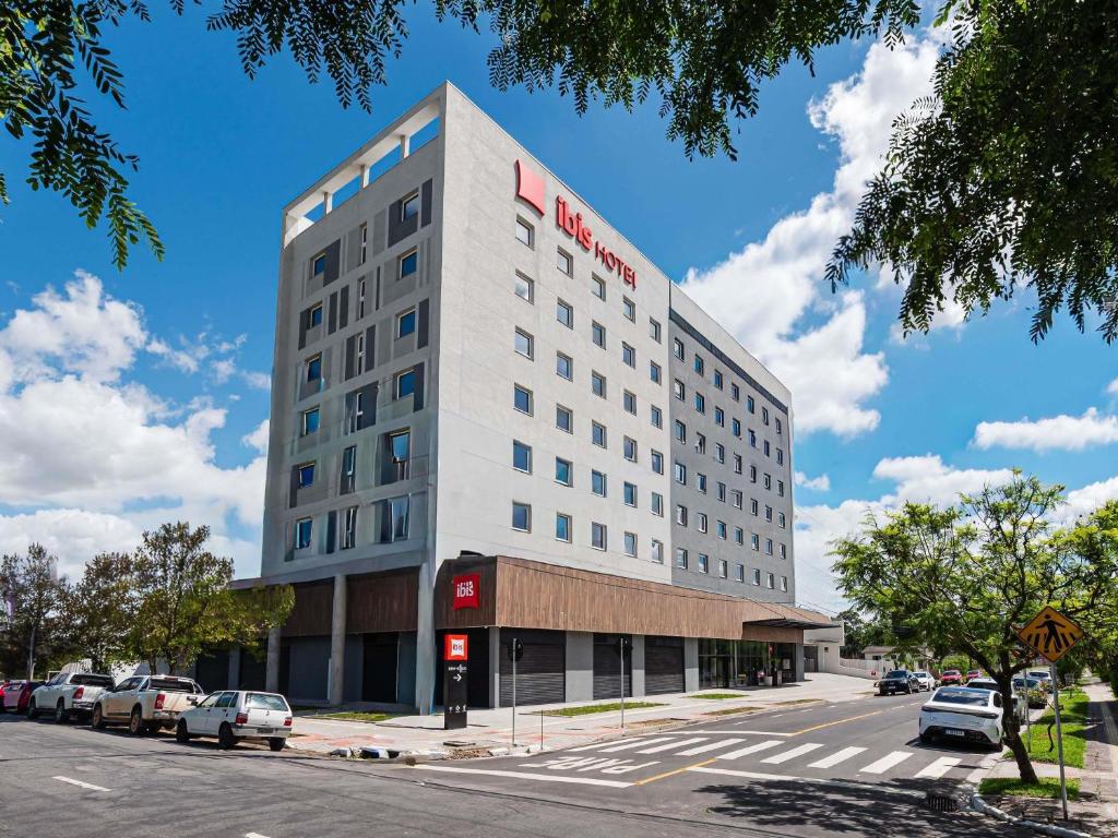 a white building with a red hotel on it at ibis Pelotas - Recem inaugurado in Pelotas