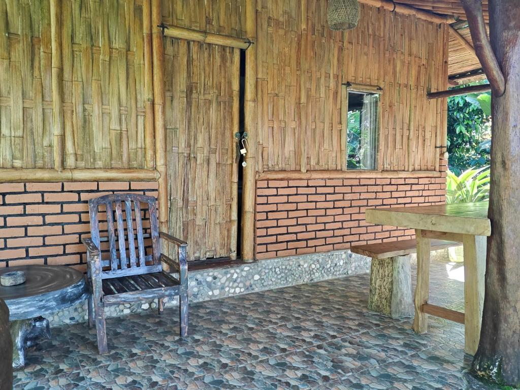 a wooden room with a chair and a table at jungle house in Jatiluwih