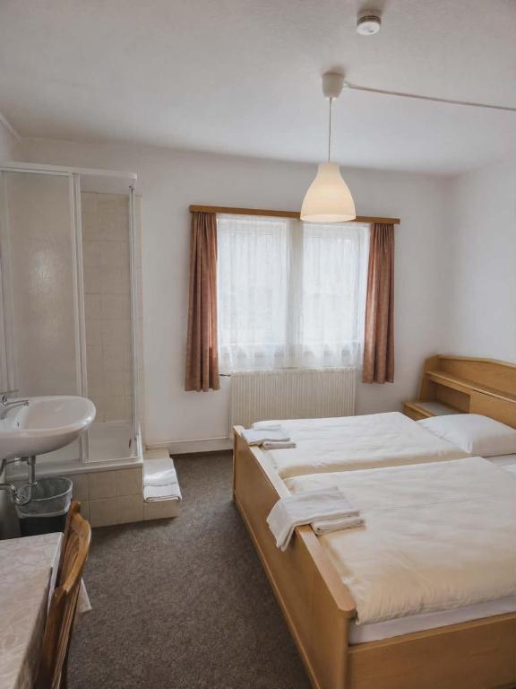 a hotel room with two beds and a sink at Hotel Ochsen in Leonberg