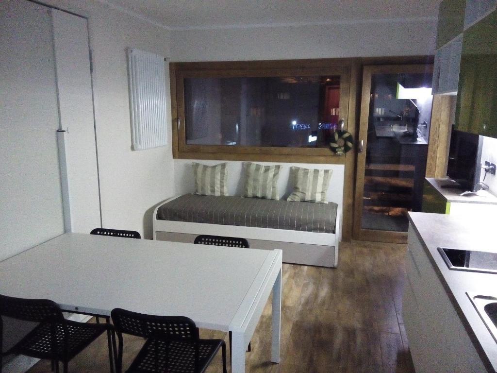 cocina pequeña con mesa, sillas y sofá en Cielo Alto Studio Apartment with wifi en Breuil-Cervinia