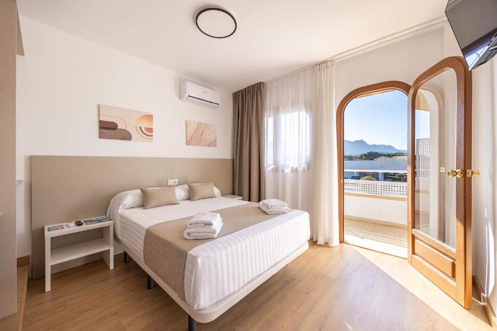a bedroom with a large bed and a large window at La Posada Boutique rooms Albir in Albir