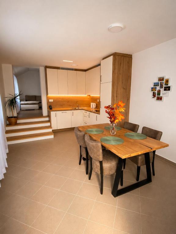 a kitchen and dining room with a wooden table and chairs at Apartma Arbores in Sveti Jurij ob Ščavnici